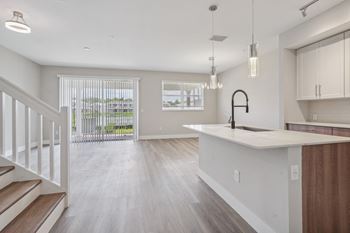 the living room and kitchen of a new home with an open floor plan at The Falls of Portofino Apartment, Naples, Florida